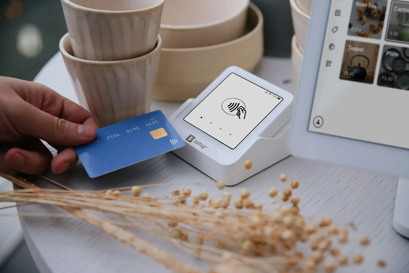 Hand tapping a contactless payment card against a card reader terminal